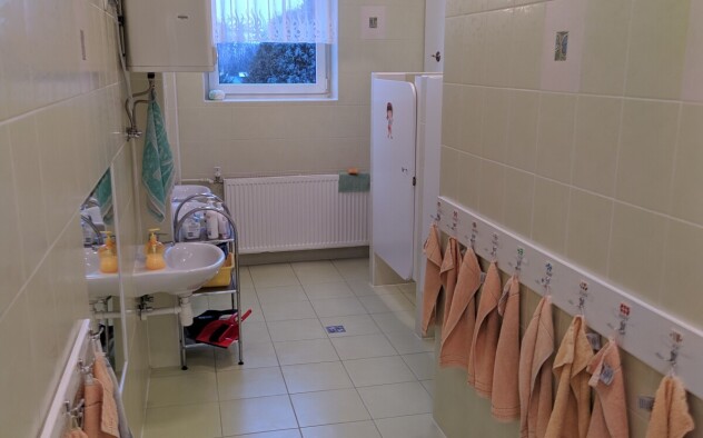 wejście do łazienki z wiszącymi po bokach ręcznikach